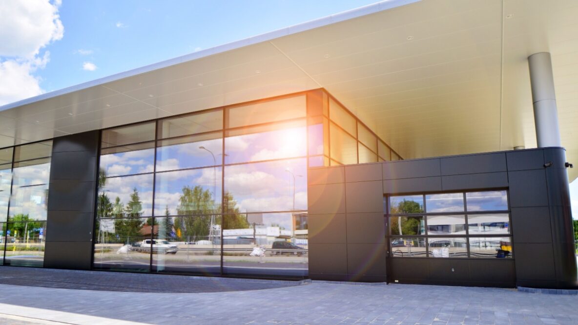 glass commercial door on car dealership with all window walls